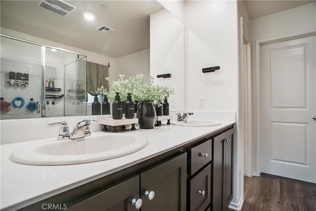 bathroom featuring a shower with door, vanity, and wood-type flooring