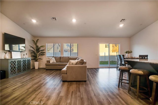 living room with dark hardwood / wood-style floors and a healthy amount of sunlight