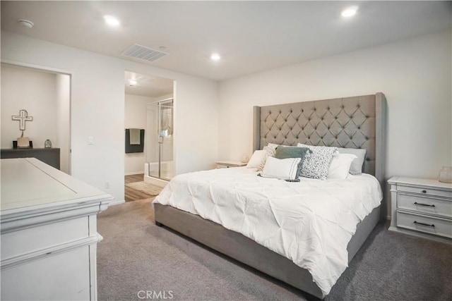 bedroom with connected bathroom and dark carpet