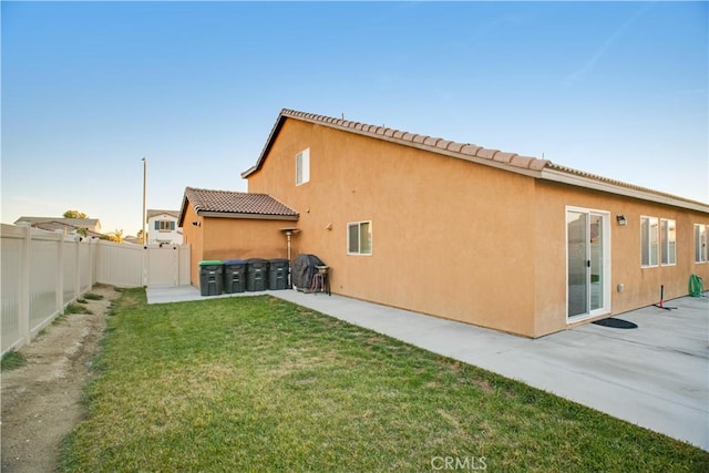 rear view of property with a patio area and a yard