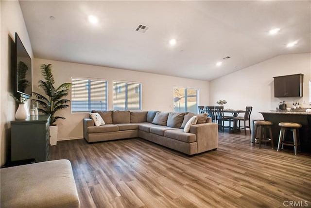 living room with dark hardwood / wood-style flooring and lofted ceiling