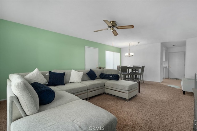 carpeted living room with ceiling fan with notable chandelier