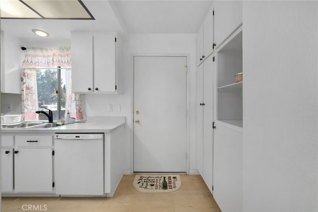 kitchen with white cabinets, white dishwasher, light hardwood / wood-style floors, and sink