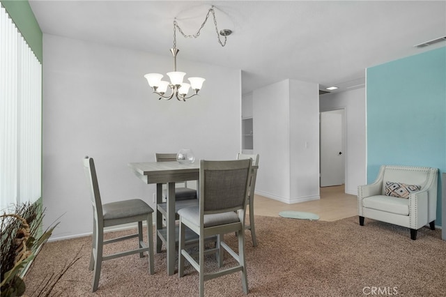 dining space with carpet flooring and a notable chandelier