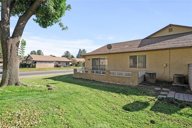 exterior space featuring a lawn and central AC