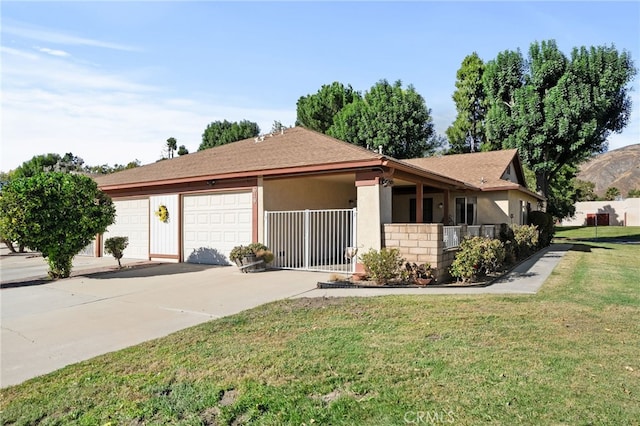 ranch-style home featuring a front yard, a garage, and covered porch