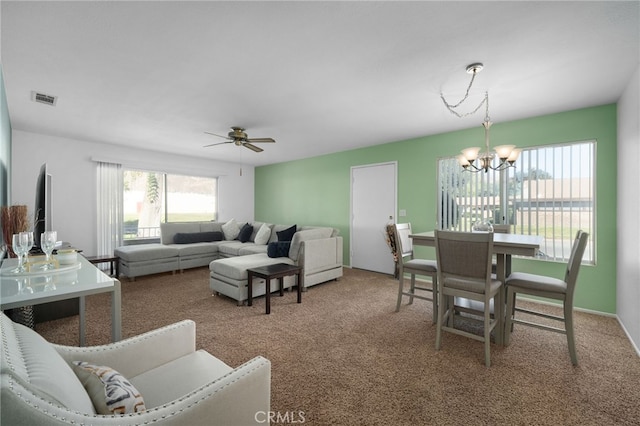 living room featuring ceiling fan with notable chandelier and carpet floors