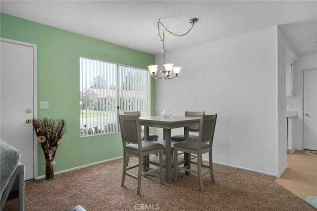 carpeted dining room with an inviting chandelier