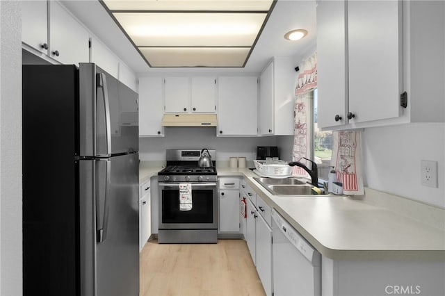 kitchen with white dishwasher, white cabinetry, stainless steel gas range, and fridge