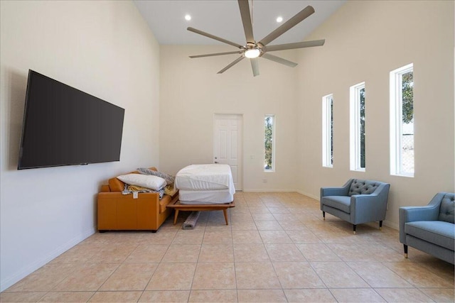 bedroom featuring ceiling fan, light tile patterned floors, high vaulted ceiling, and multiple windows