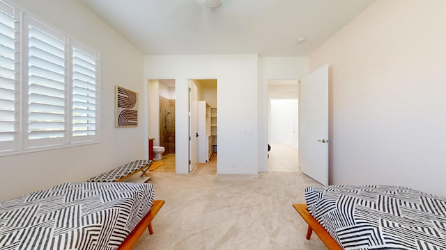 bedroom featuring ensuite bathroom and light colored carpet