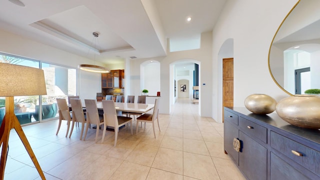 dining room with a tray ceiling and light tile patterned floors