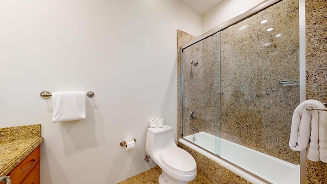 full bathroom with combined bath / shower with glass door, toilet, and vanity