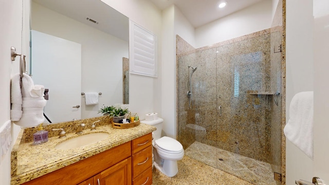 bathroom with vanity, toilet, and a shower with shower door