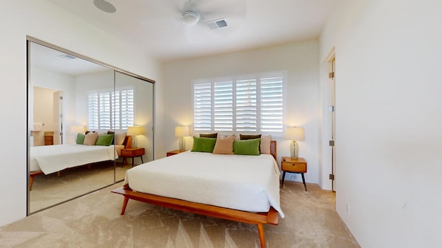 carpeted bedroom featuring ceiling fan and a closet