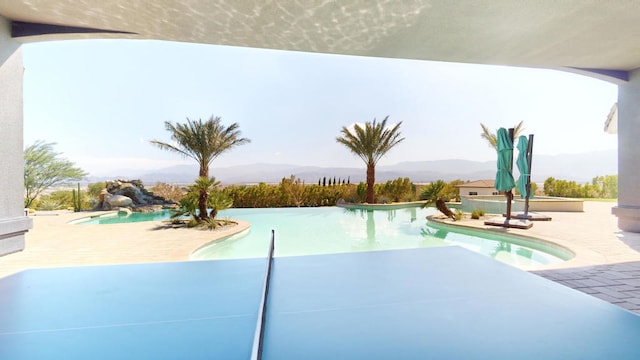 view of pool with a patio area and a mountain view