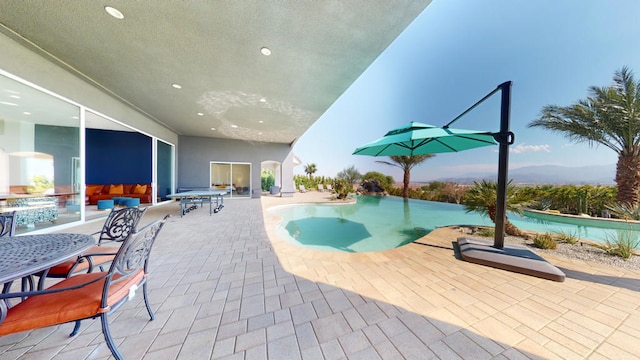 view of swimming pool with a mountain view and a patio area