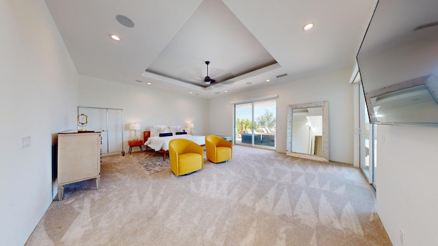 bedroom featuring access to exterior, light colored carpet, and a tray ceiling