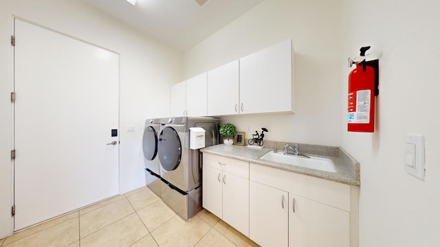 washroom with washing machine and clothes dryer, light tile patterned floors, cabinets, and sink