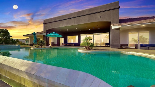 pool at dusk with a patio