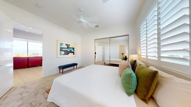 bedroom featuring ceiling fan, a closet, and light carpet