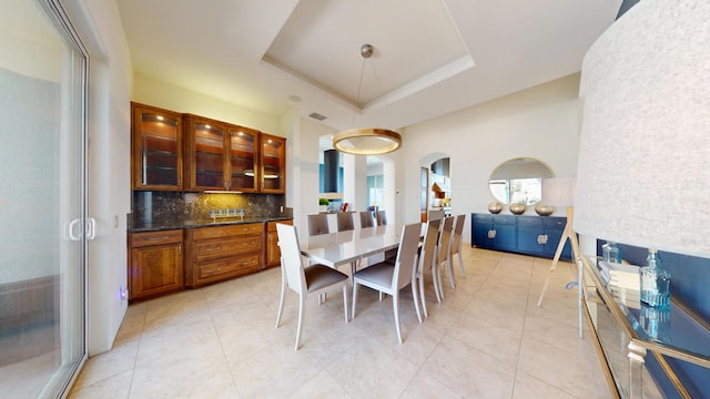 tiled dining space featuring a tray ceiling