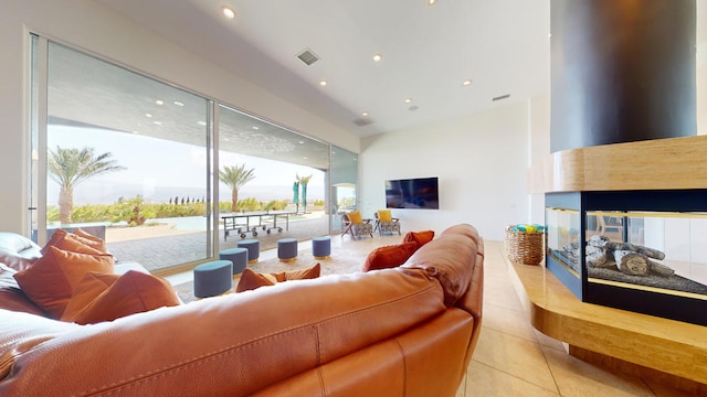 living room with a multi sided fireplace and light tile patterned flooring