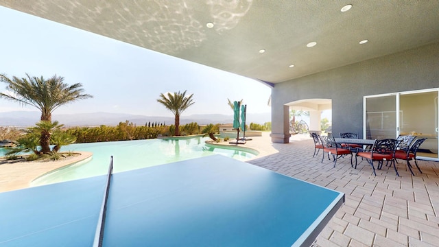 view of pool with a mountain view and a patio