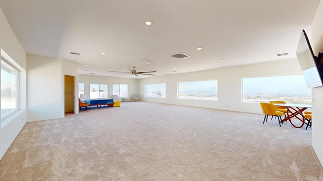 interior space with ceiling fan and light colored carpet