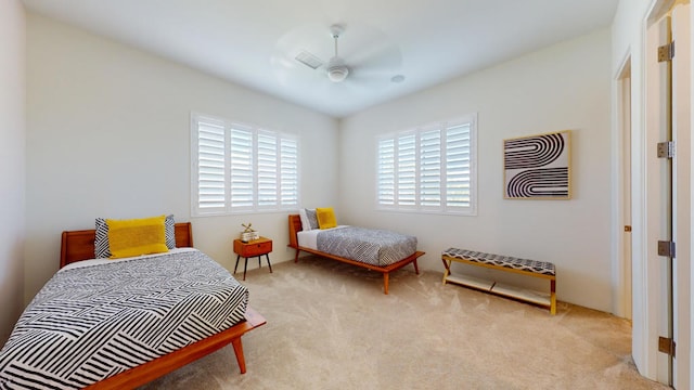 bedroom with multiple windows, ceiling fan, and light colored carpet