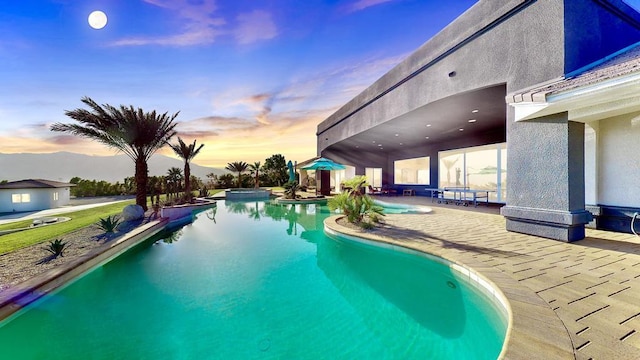 pool at dusk with a patio