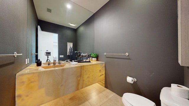 bathroom featuring tile patterned flooring, toilet, lofted ceiling, and sink