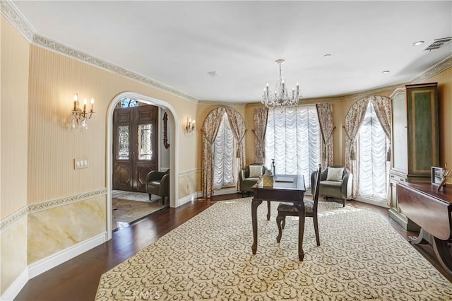 dining area with ornamental molding, an inviting chandelier, and dark wood-type flooring