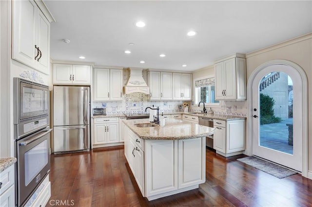 kitchen featuring custom range hood, dark hardwood / wood-style flooring, white cabinetry, and appliances with stainless steel finishes