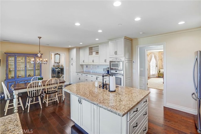 kitchen with dark hardwood / wood-style flooring, decorative light fixtures, white cabinetry, and tasteful backsplash