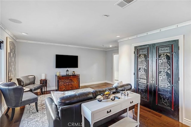 living room with wood-type flooring and crown molding