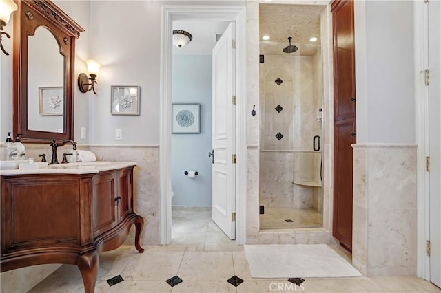 bathroom with vanity, tile walls, and a shower with shower door