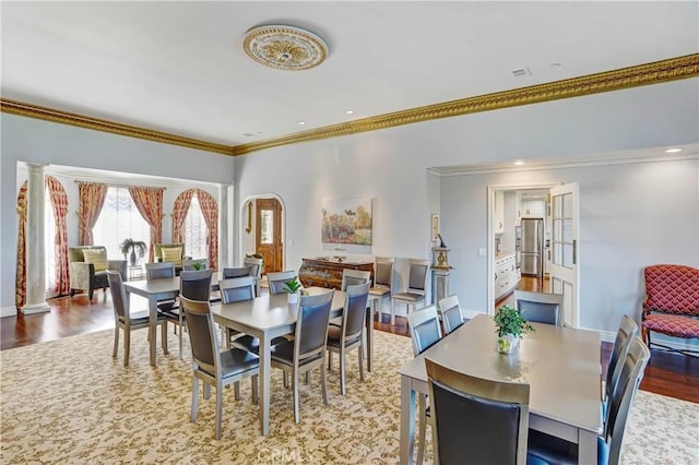 dining area featuring wood-type flooring and ornamental molding