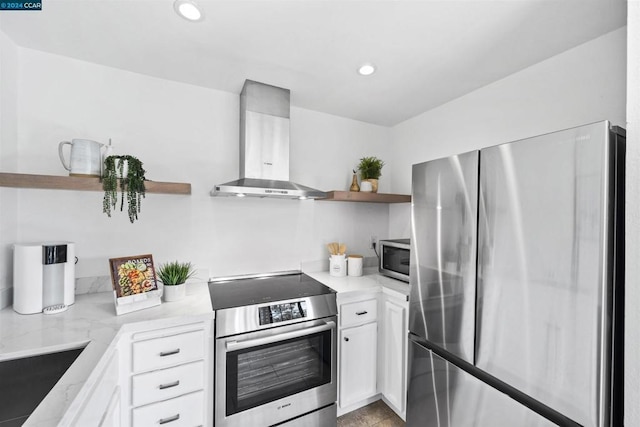 kitchen featuring light stone countertops, sink, wall chimney exhaust hood, white cabinets, and appliances with stainless steel finishes