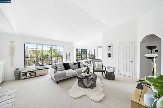 living room with light colored carpet and vaulted ceiling