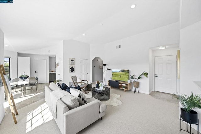 carpeted living room featuring vaulted ceiling