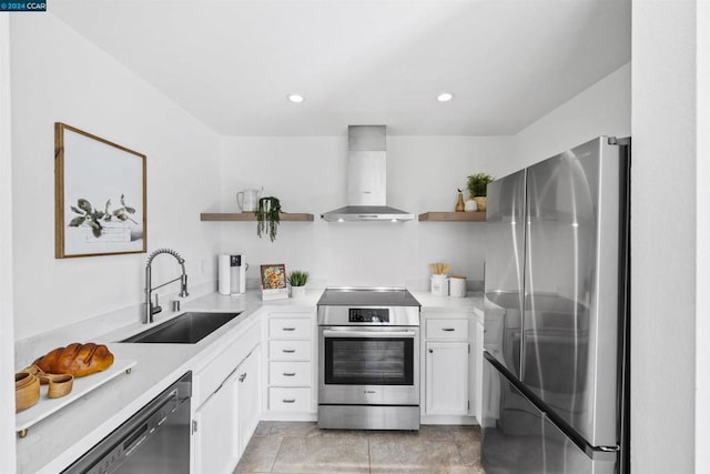 kitchen featuring stainless steel appliances, sink, wall chimney range hood, light tile patterned floors, and white cabinetry