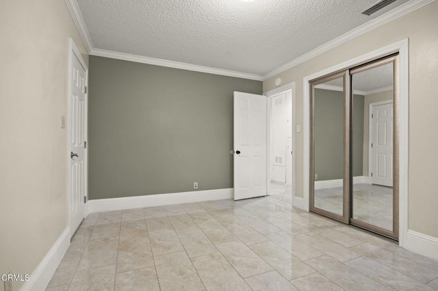 tiled empty room featuring crown molding and a textured ceiling