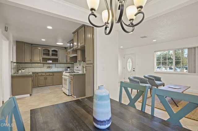 tiled dining area featuring sink, ornamental molding, and an inviting chandelier