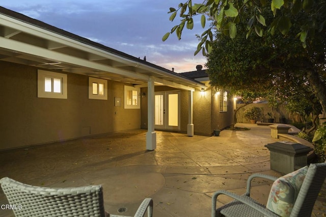 patio terrace at dusk featuring french doors