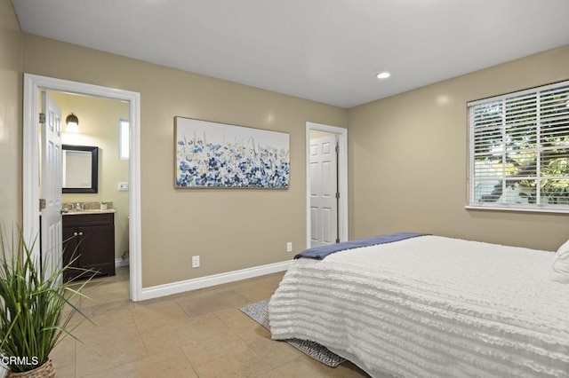 bedroom with ensuite bath, sink, and light tile patterned floors