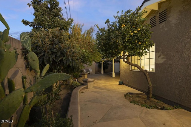 property exterior at dusk featuring a patio