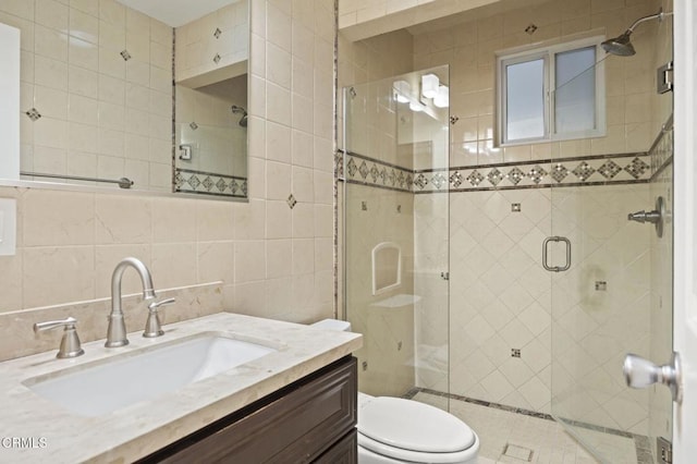 bathroom with tasteful backsplash, an enclosed shower, toilet, vanity, and tile walls