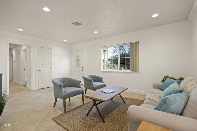 living room with light tile patterned floors, a textured ceiling, and ornamental molding