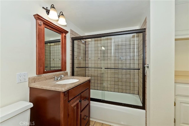 full bathroom with tile patterned floors, vanity, enclosed tub / shower combo, and toilet